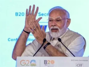 Prime Minister Narendra Modi delivering a speech on artificial intelligence with a digital AI brain graphic in the background during a technology summit.
