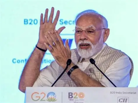 Prime Minister Narendra Modi delivering a speech on artificial intelligence with a digital AI brain graphic in the background during a technology summit.