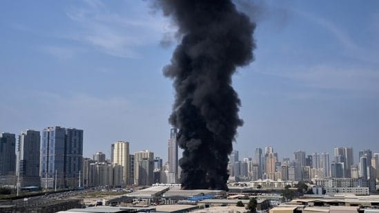 Composite news graphic showing explosions over the skylines of Dubai, Abu Dhabi, and Doha, with missile interceptions lighting up the night sky and air raid sirens sounding in Tel Aviv during escalating Middle East conflict.